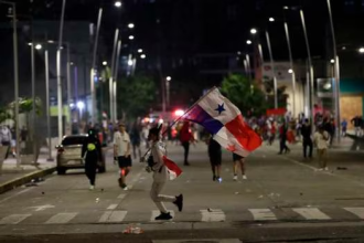 Manifestantes se enfrentan a la Policía al final de una nueva jornada de protestas contra el contrato entre el Estado y Minera Panamá, subsidiaria de la canadiense First Quantum Mineral (FQM), en Ciudad de Panamá. Foto: EFE - Bienvenido Velasco