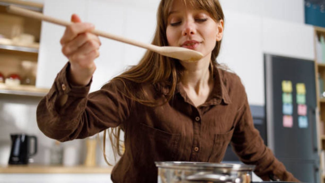 Cómo evitar que la suciedad se acumule en tu estufa al cocinar usando una cuchara de madera.