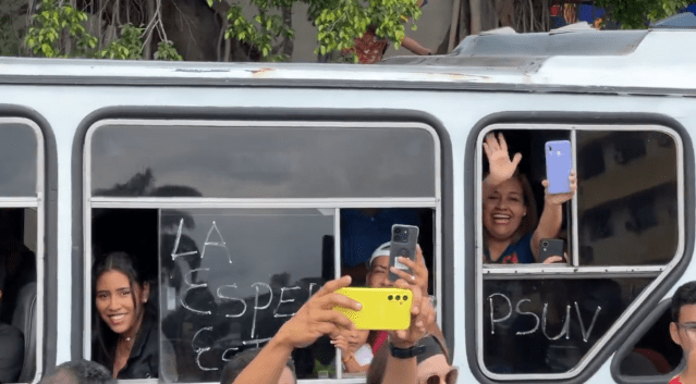 Gente a bordo de autobuses identificados con el Psuv saludan a María Corina