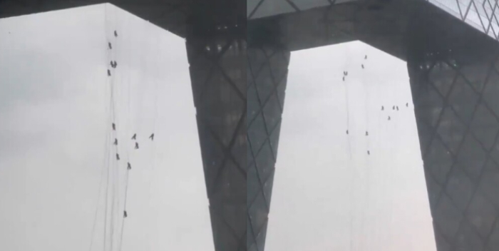Los hombres en cuestión son empleados de la CCTV Tower, quienes quedaron pendiendo de cuerdas por algunos minutos tras las ráfagas que  alcanzaron niveles de entre 60 y 100 kilómetros por hora, causando caos en toda la ciudad.