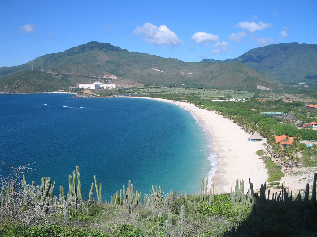 A beach in Margarita Island (Venezuela) called Playa Puerto Cruz. Hotel at the right is the Dunes Beach Resort Hotel. In the background is the Hesperia Isla Bonita Hotel. The picture was taken from the lighthouse.
